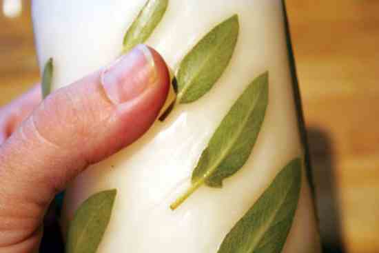 
After you’ve dipped or rolled the candle in wax, press any leaves or stems sticking out into the warm wax and they should stay flat.
